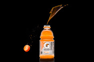 a bottle of gatorade with a logo made from splashes of the liquid